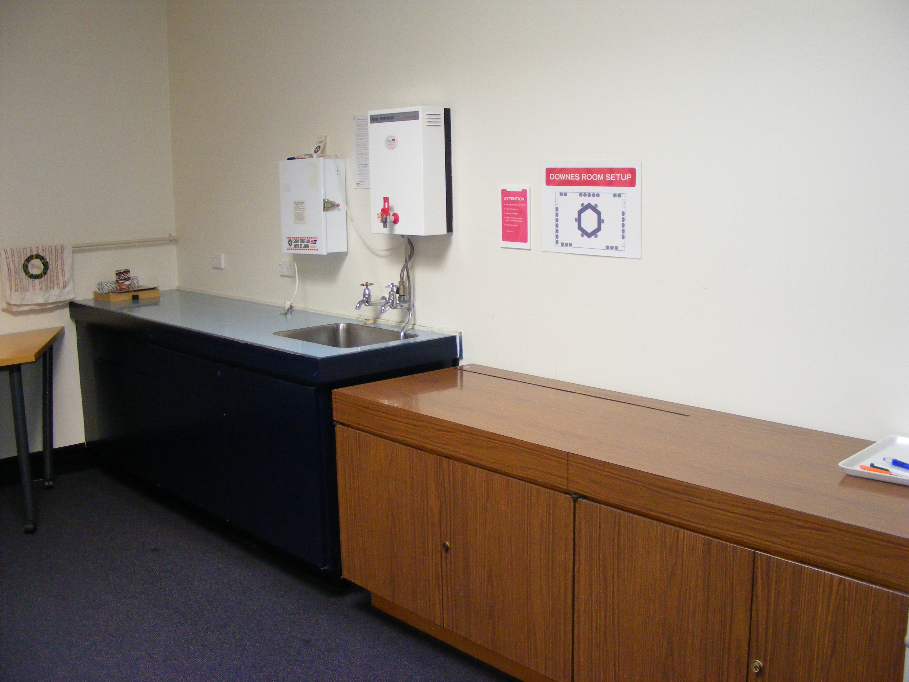 A kitchenette with a sink and hot water